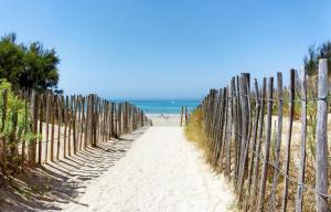 a fence on the beach with the ocean in the background at Chez mamie in La Rochelle