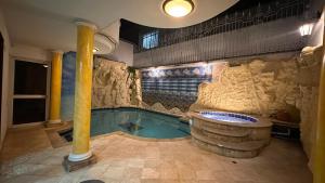 a swimming pool with a tub in a building at Hotel Casa Sharon in Cali