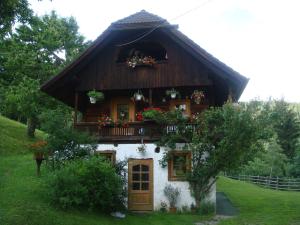 a house with a balcony with flowers on it at Ferienwohnung Lahnerhof in Arriach