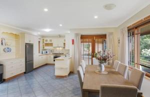 a kitchen and dining room with a table and chairs at Twilight Ridge in Bega