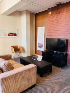 a living room with a couch and a flat screen tv at iNtsika Boutique in Johannesburg