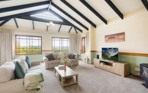 a living room with couches and a tv at Twilight Ridge in Bega