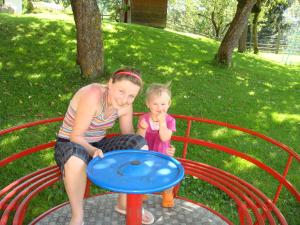 a woman and a little girl playing on a playground at Ferienwohnung Lahnerhof in Arriach