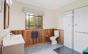 a bathroom with a toilet and a sink and a shower at Twilight Ridge in Bega +40 photos