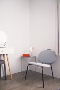 a chair and a table with a lamp in a room at Prouds House in Ban Hua Phlong