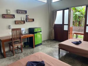 a room with a desk and a green refrigerator at Slow Life Sabaidee Pai in Pai