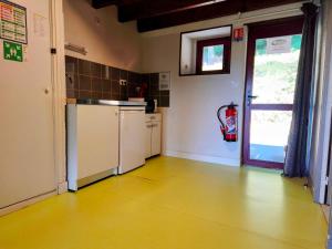 a kitchen with a white refrigerator and a window at Gite la Borie de Pourtou Santoire in Condat