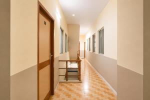 a hallway with a wooden door and a table at FabHotel Mara Residency in Chennai