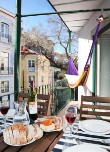 una mesa con una botella de vino y pan. en Alfama - 28888AL, en Lisboa