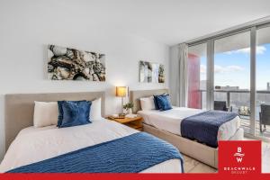 two beds in a room with a window at New High-Floor Studio Bay & Private Balcony in Hallandale Beach