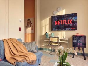 a living room with a blue couch and a tv at Homeby, Cinisca Suite Rose in Bologna +6 photos