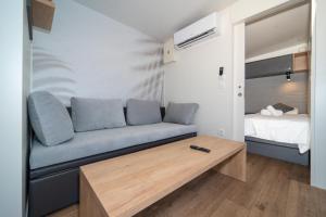 a living room with a couch and a bed at Camping Nevia - Mobile Homes with Heated Private Pool in Neviđane +48 photos