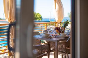 a table with a bowl of fruit on it on a balcony at Camping Nevia - Mobile Homes with Heated Private Pool in Neviđane