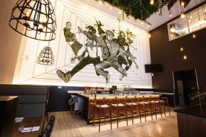 a restaurant with a bar with a painting on the wall at INNSiDE by Meliá New York Nomad in New York