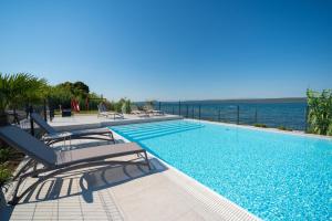 a swimming pool with a view of the ocean at Camping Nevia - Mobile Homes with Heated Private Pool in Neviđane