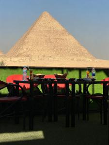 a table and chairs in front of a pyramid at Master kings of the pyramids and Sphinx in Cairo