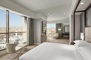 a hotel room with a bed and a large window at Jabal Omar Hyatt Regency Makkah in Mecca +119 photos