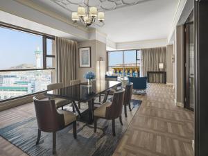 a dining room with a table and chairs and a large window at Jabal Omar Hyatt Regency Makkah in Mecca