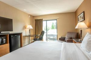 a hotel room with a bed and a television at Clarion Pointe in Campbellton