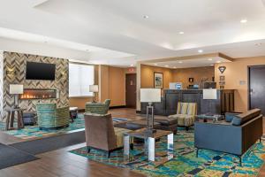 a hotel lobby with furniture and a fireplace at Comfort Inn & Suites Airport North in Calgary
