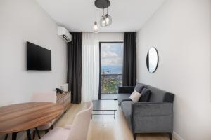 a living room with a couch and a table at STEPS Batumi Hotel & Suites in Batumi