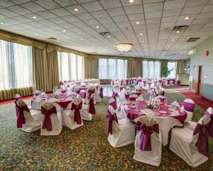 a banquet hall with white tables and purple bows at Comfort Inn Conference Center Pittsburgh Penn Hills in Churchill +29 photos