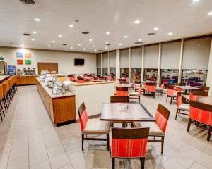 a dining room with tables and chairs in a restaurant at Comfort Inn Conference Center Pittsburgh Penn Hills in Churchill