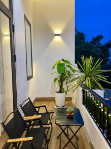 a balcony with two chairs and a table and a plant at Mẹ Nhím homestay in Chung Cap +8 photos