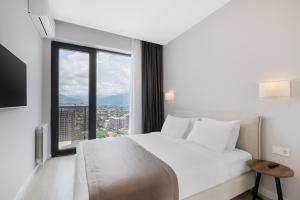 a bedroom with a white bed and a large window at STEPS Batumi Hotel & Suites in Batumi +28 photos