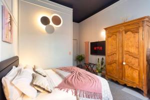 ein Schlafzimmer mit einem Bett und einem Holzschrank in der Unterkunft Homeby, Cinisca Suites in Bologna