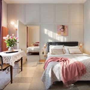 ein Schlafzimmer mit einem Bett, einem Tisch und einem Spiegel in der Unterkunft Homeby, Cinisca Suites in Bologna