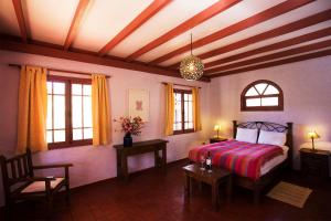1 dormitorio con 1 cama, 2 mesas y ventanas en Hacienda Los Andes, en Hurtado