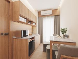 a small kitchen and dining room with a table at Victoria Nimman Hotel in Chiang Mai