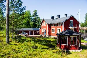 a red house with a gazebo in a yard at Gopshusgården - Rum & Stugor in Mora