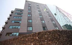 a tall building in front of a building under construction at Ulsan Seongnam Hotel Mar in Ulsan
