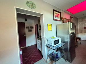 a kitchen with a refrigerator and a microwave on a table at La Tuilerie Lixy Brannay in Brannay