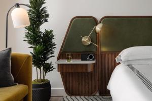 a bedroom with a bed with a side table and a lamp at Thompson Houston, by Hyatt in Houston