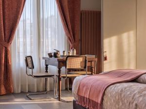 ein Schlafzimmer mit einem Tisch und Stühlen neben einem Bett in der Unterkunft Homeby, Cinisca Suites in Bologna + 25 Fotos
