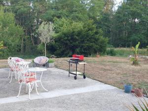 a table and chairs and a table with a laptop on it at La Tuilerie Lixy Brannay in Brannay