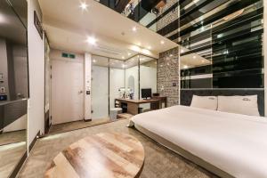 a bedroom with a large white bed and a desk at Ulsan Seongnam Hotel Mar in Ulsan