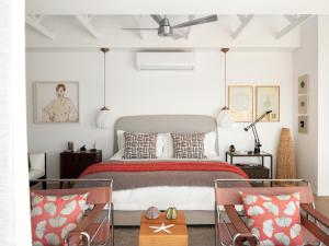 a bedroom with a large bed and two chairs at The Lighthouse in Simonʼs Town +66 photos