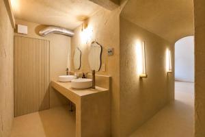 a bathroom with two sinks and two mirrors at Villa KULM in Minamiawaji