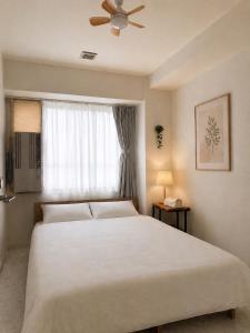 a bedroom with a large white bed and a window at O2 capsule house OTARU in Otaru +131 photos