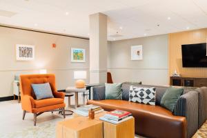 a living room with a couch and a tv and chairs at Hotel Downstreet, an Ascend Collection Hotel in North Adams