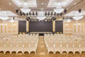 an empty auditorium with white chairs and a stage at Meliá Vinpearl Phu Ly in Phủ Lý