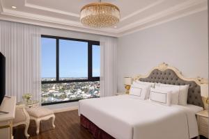 a white bedroom with a large bed and a large window at Meliá Vinpearl Phu Ly in Phủ Lý