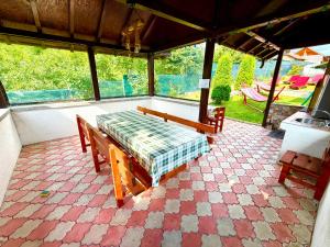 a patio with two benches and a table and chairs at Casa David Comarnic in Comarnic