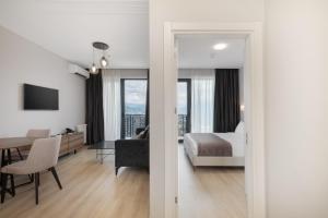 a bedroom with a bed and a living room at STEPS Batumi Hotel & Suites in Batumi