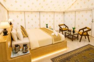 a bedroom with a bed and a table and chairs at Desert Popular Resort & Camp in Jaisalmer +153 photos