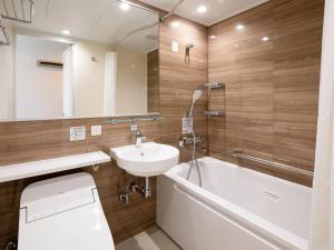 a bathroom with a sink and a tub and a toilet at Comfort Hotel Chitose in Chitose +34 photos